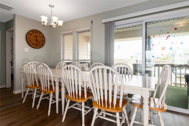 dining area with hardwood / wood-style flooring and a notable chandelier