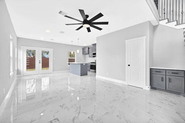 unfurnished living room with sink, french doors, and ceiling fan