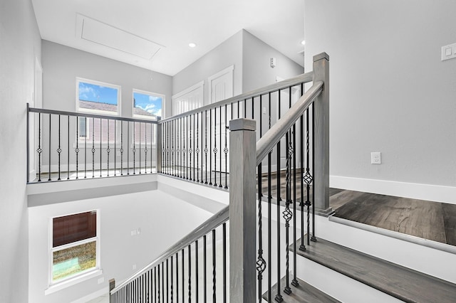 stairway featuring a towering ceiling and a wealth of natural light