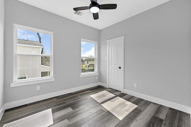 spare room featuring dark wood-type flooring and ceiling fan