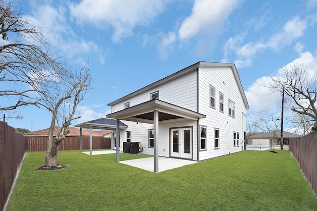 back of property with a lawn, central AC unit, and a patio area