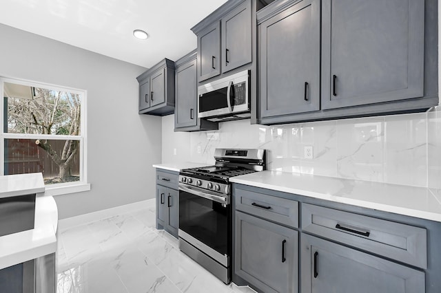 kitchen featuring tasteful backsplash, gray cabinets, and appliances with stainless steel finishes