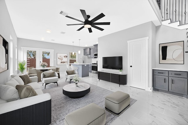 living room featuring sink, french doors, and ceiling fan