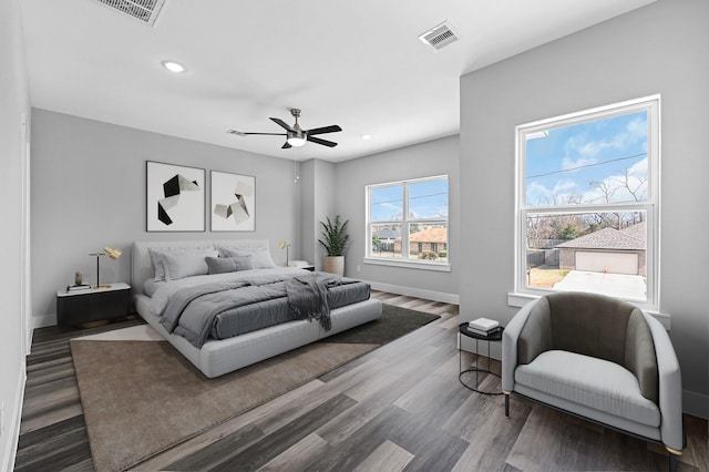 bedroom with dark hardwood / wood-style flooring and ceiling fan