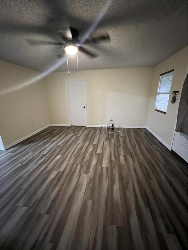 bonus room with ceiling fan, dark wood-type flooring, and a textured ceiling