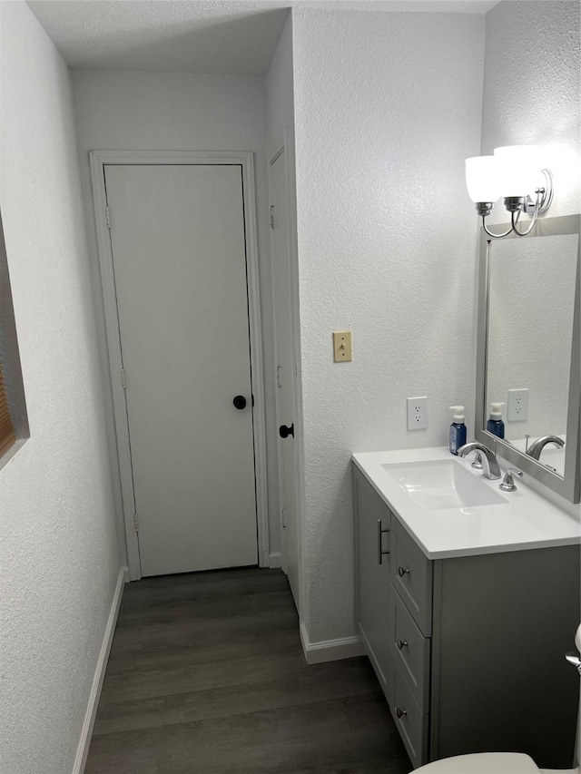 bathroom featuring hardwood / wood-style flooring, vanity, and a textured ceiling