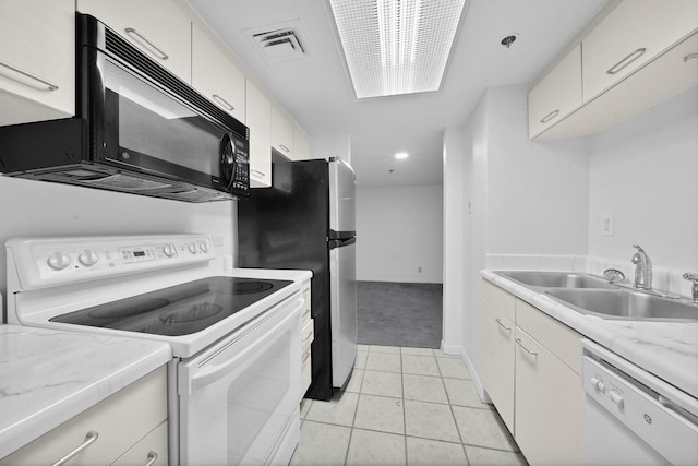 kitchen featuring white cabinetry, sink, light tile patterned floors, and white appliances