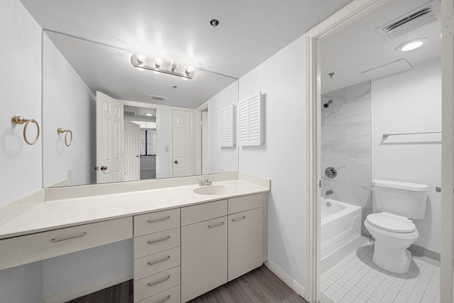 full bathroom featuring vanity, toilet, tiled shower / bath combo, and hardwood / wood-style floors