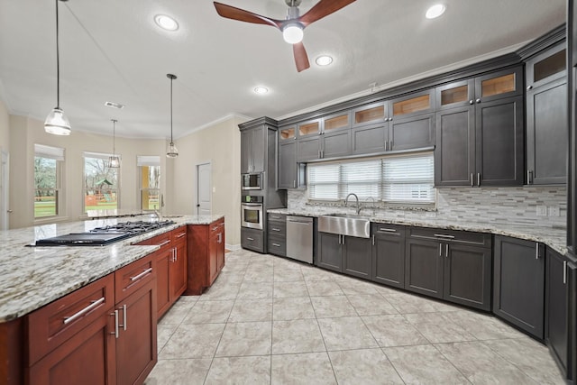 kitchen with appliances with stainless steel finishes, pendant lighting, sink, decorative backsplash, and light tile patterned floors