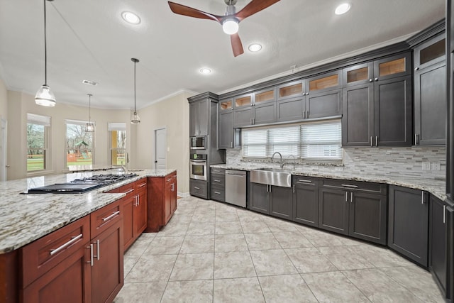 kitchen featuring appliances with stainless steel finishes, a sink, a ceiling fan, backsplash, and ornamental molding