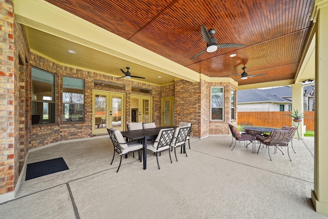view of patio featuring outdoor dining area, french doors, fence, and ceiling fan
