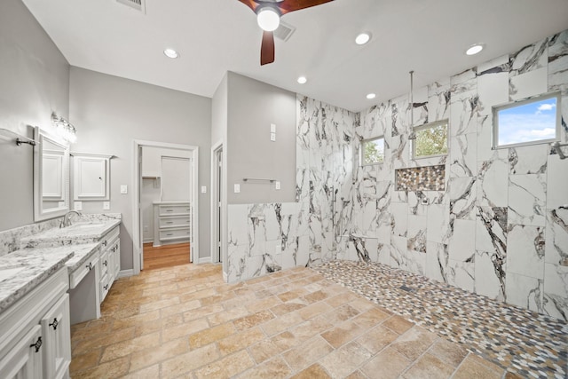 bathroom featuring vanity, ceiling fan, and tiled shower