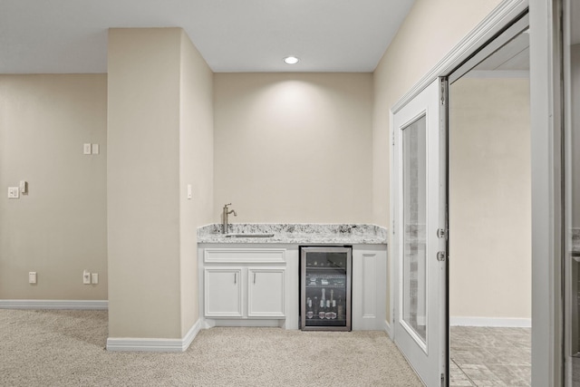 indoor wet bar with wine cooler, light carpet, baseboards, and recessed lighting