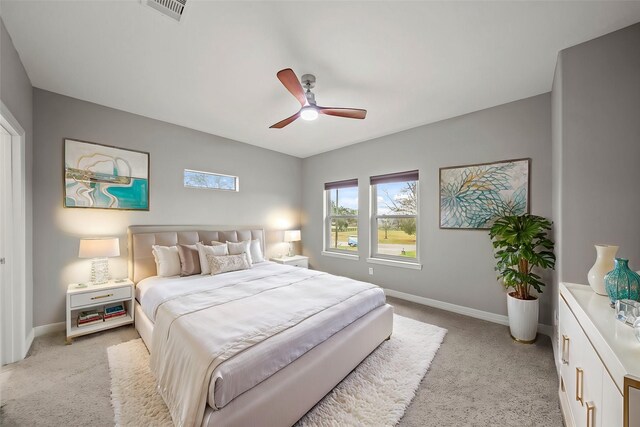 bedroom featuring light carpet, baseboards, and a ceiling fan