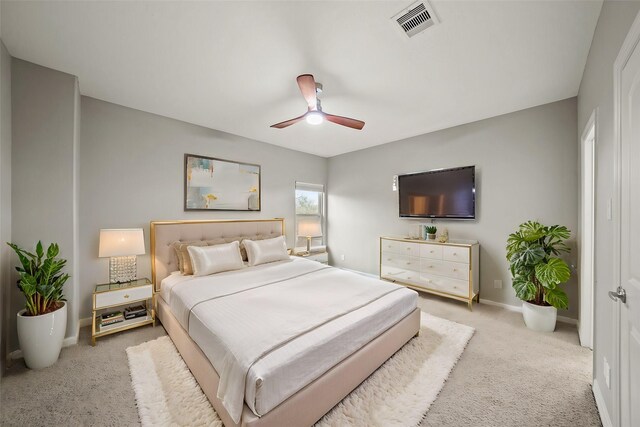 bedroom with light colored carpet, baseboards, and a ceiling fan
