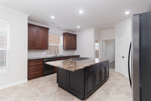 kitchen featuring sink, stainless steel refrigerator, dishwasher, dark brown cabinetry, and a kitchen island