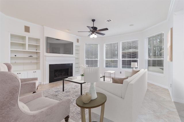 tiled living room featuring ornamental molding, built in features, and ceiling fan