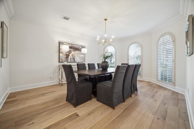 dining room featuring crown molding, a notable chandelier, and light hardwood / wood-style flooring