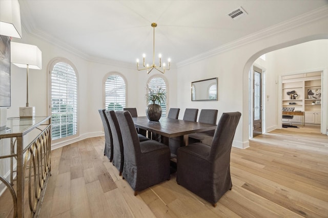 dining room featuring an inviting chandelier, ornamental molding, and light wood-type flooring