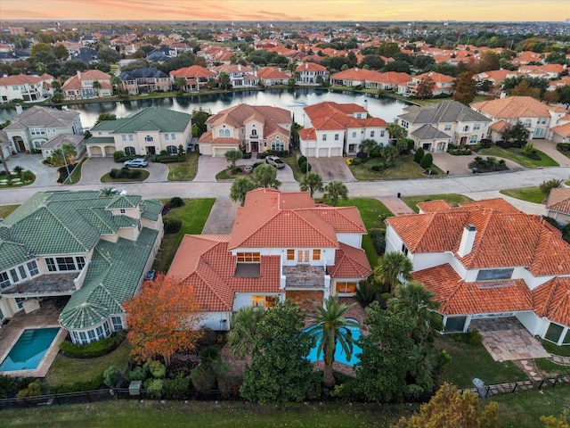 aerial view at dusk featuring a water view