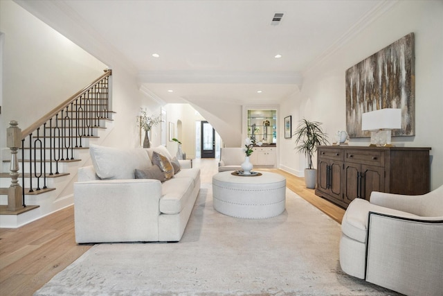 living room featuring crown molding and light hardwood / wood-style flooring