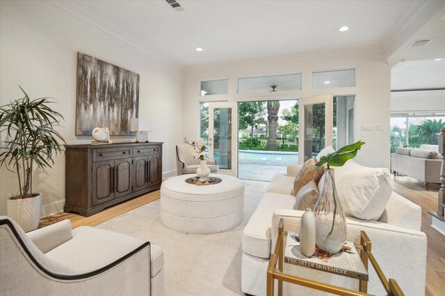 living room with ornamental molding and light hardwood / wood-style floors