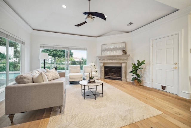 living room with ornamental molding, wood-type flooring, vaulted ceiling, and a wealth of natural light