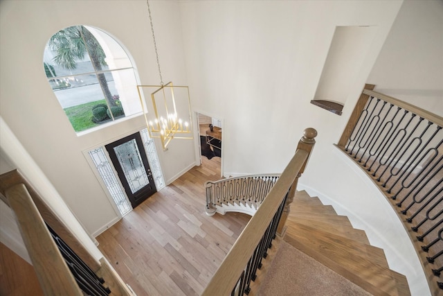 entryway featuring a notable chandelier, light hardwood / wood-style flooring, and a high ceiling