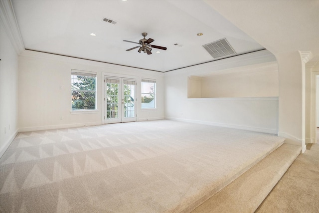 carpeted spare room with ornamental molding, ceiling fan, and french doors