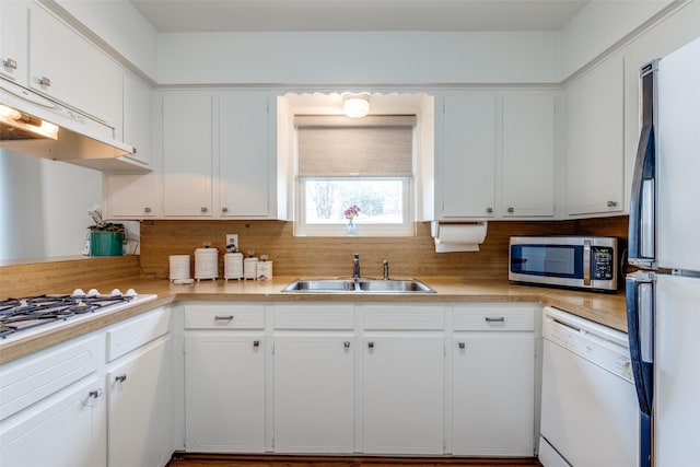 kitchen with stainless steel appliances, white cabinetry, sink, and decorative backsplash