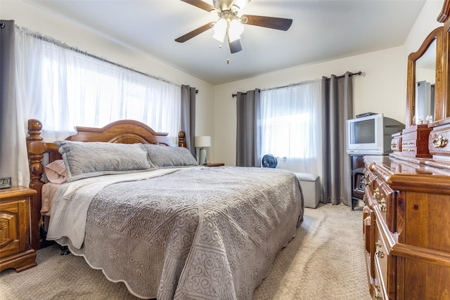 carpeted bedroom with ceiling fan and multiple windows