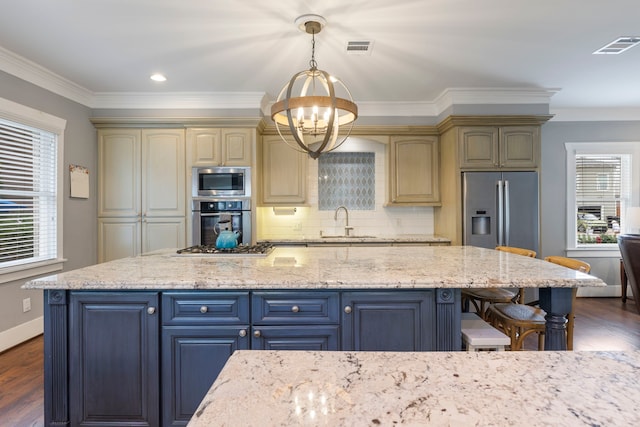 kitchen with light stone counters, sink, cream cabinets, and stainless steel appliances