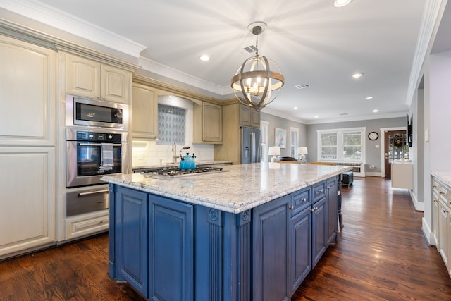 kitchen with appliances with stainless steel finishes, dark hardwood / wood-style floors, hanging light fixtures, light stone counters, and cream cabinetry