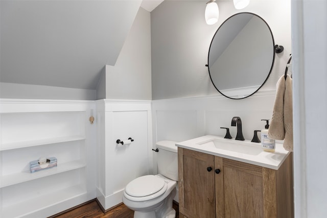 bathroom featuring vanity, wood-type flooring, vaulted ceiling, and toilet