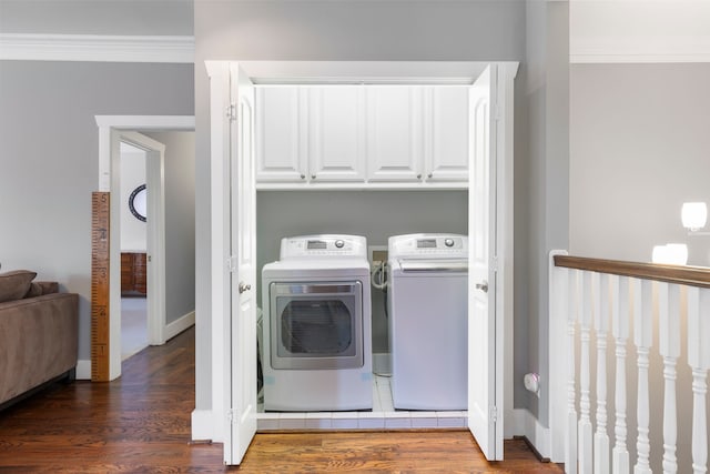 laundry area featuring cabinets, ornamental molding, dark hardwood / wood-style flooring, and washer and dryer