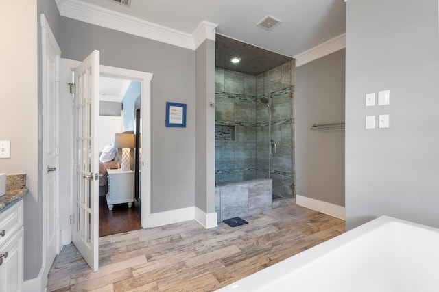 bathroom featuring walk in shower, ornamental molding, wood-type flooring, and vanity