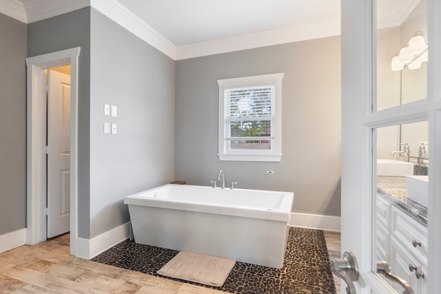 bathroom with vanity, ornamental molding, and a bathing tub