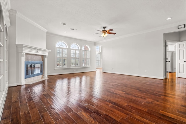 unfurnished living room featuring a fireplace, dark hardwood / wood-style flooring, ceiling fan, crown molding, and a textured ceiling