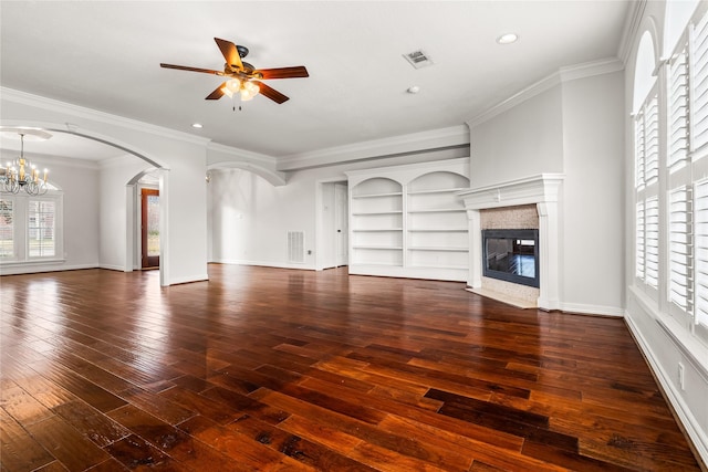 unfurnished living room featuring dark hardwood / wood-style floors, ceiling fan with notable chandelier, built in features, a high end fireplace, and crown molding