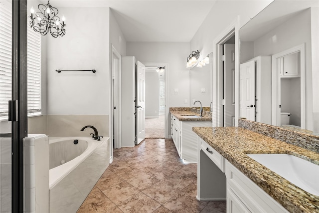 bathroom featuring tile patterned floors, vanity, and tiled bath