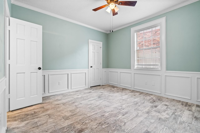 empty room with ornamental molding, light hardwood / wood-style floors, and ceiling fan