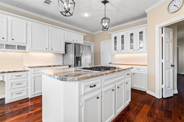 kitchen with pendant lighting, white cabinetry, stainless steel appliances, and a center island