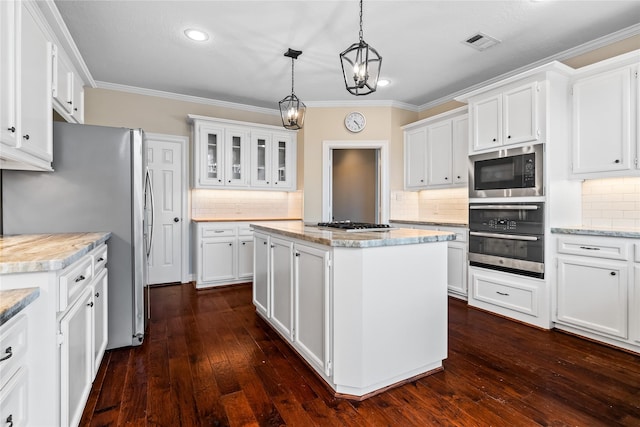 kitchen featuring a kitchen island, appliances with stainless steel finishes, pendant lighting, and white cabinets