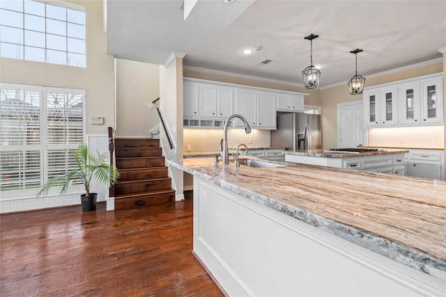 kitchen with white cabinetry, sink, decorative light fixtures, and stainless steel refrigerator with ice dispenser