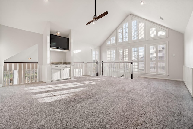 unfurnished living room featuring high vaulted ceiling, ceiling fan, and carpet