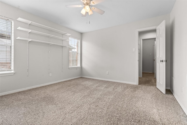 carpeted spare room featuring ceiling fan