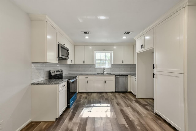 kitchen with sink, white cabinetry, backsplash, stainless steel appliances, and dark hardwood / wood-style floors