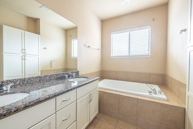 bathroom featuring vanity, plenty of natural light, tile patterned floors, and tiled bath