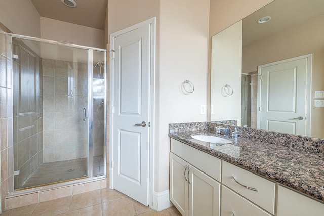 bathroom with tile patterned floors, a shower with shower door, and vanity