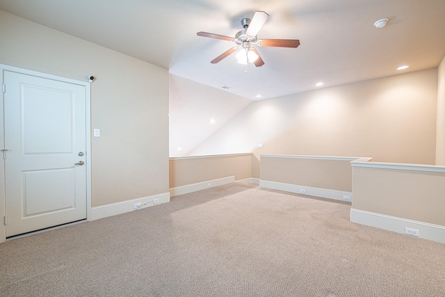 spare room with vaulted ceiling, carpet flooring, and ceiling fan